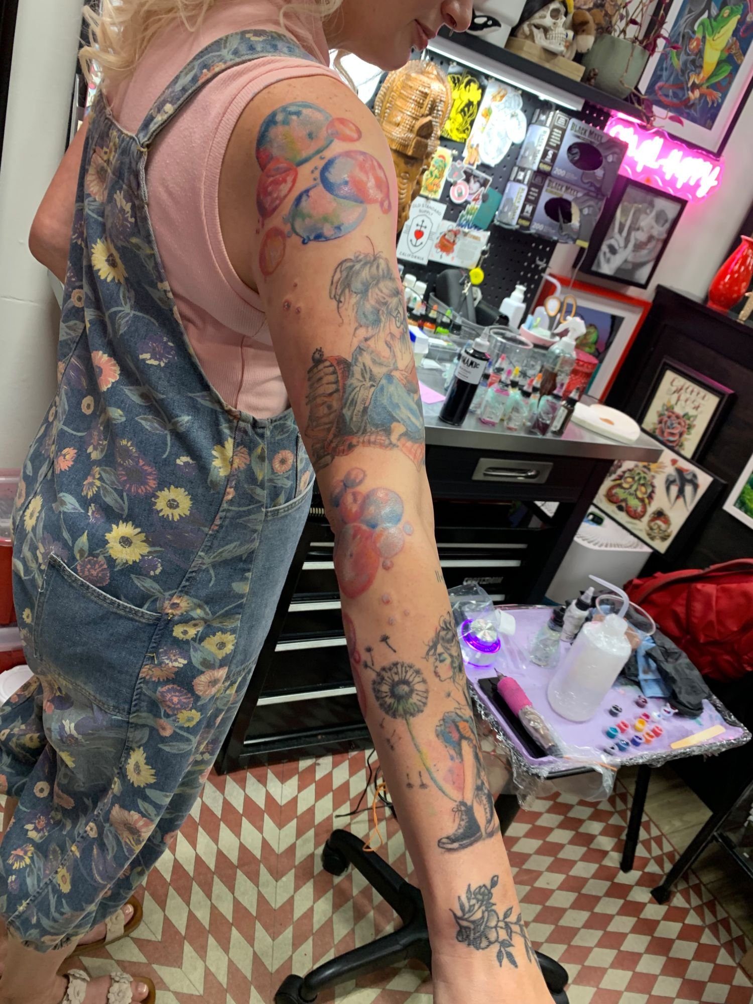 Arm with soap bubbles, girl reading and dandelion tattoos