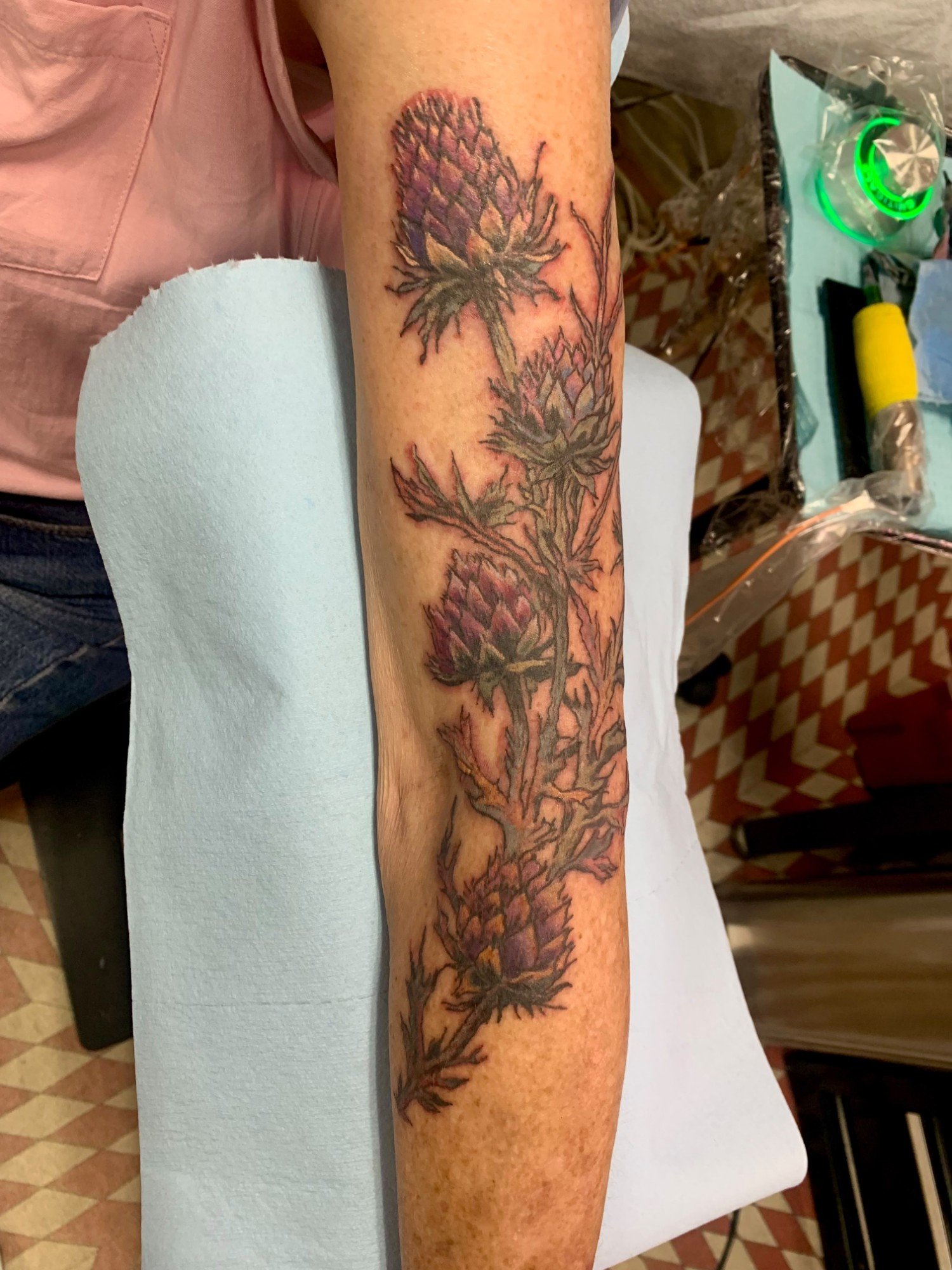 Purple thistle color realism tattoo along the forearm